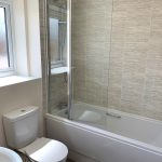 Modern bathroom with toilet, bathtub, and shower.