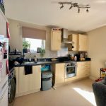 Cosy kitchen with modern appliances and light wood cabinets.