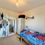 Children's bedroom with toys and colourful duvet.