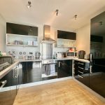Modern kitchen with black cabinets and appliances.