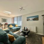 Modern living room with teal sofas and artwork.