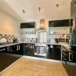 Modern kitchen with black cabinets and stainless steel appliances.