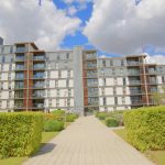 Modern apartment building with landscaped gardens.