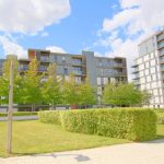 Modern apartment buildings with landscaped gardens.
