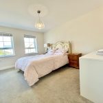 Cosy bedroom with double bed and two windows.