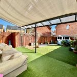 Covered garden patio with lush artificial grass