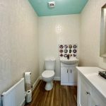 Stylish modern bathroom with patterned wallpaper.