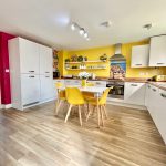 Colourful kitchen with yellow accents and modern furniture.
