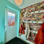 Colourful hallway with coats and hats on hooks.