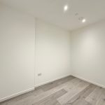 Empty modern room with wooden floor and white walls.