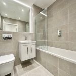 Modern bathroom with tiled walls and fixtures.