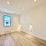 Bright modern empty room with wooden floor and window.