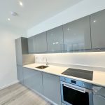 Modern kitchen with grey cabinets and induction hob.
