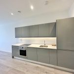 Modern kitchen with grey cabinets and appliances.
