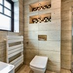 Modern bathroom with stone tiles and toilet.