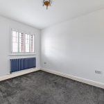 Empty white room with carpet and window shutter.