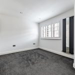 Bright empty room with grey carpet.