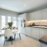 Modern kitchen with dining area and plants.