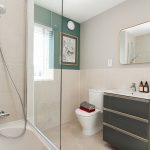 Modern bathroom with shower, vanity, and toilet.