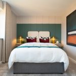 Modern bedroom with double bed and abstract artwork.