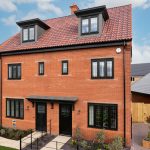 Newly built red-brick house with marketing office nearby.