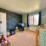 Bright children's bedroom with toys and cot.