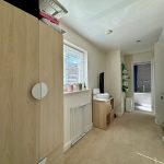 Spacious hallway leading to modern bathroom.