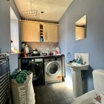 Utility room with washer, dryer, and sink.