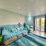 Bright living room with blue furniture and garden view.