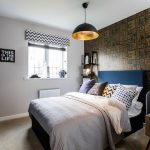 Stylish bedroom with patterned wallpaper and modern decor.