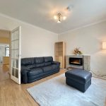 Cosy living room with sofa and fireplace.