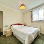 Cosy bedroom with double bed and floral curtains.