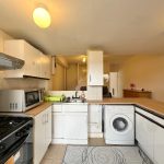 Modern kitchen with appliances and wood countertops.