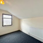 Small, empty room with window and radiator.