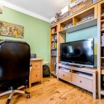 Home office with desk, chair, and bookshelf.