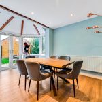 Bright dining area with telescope and wooden table.