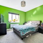 Bedroom with green walls and modern furnishings.