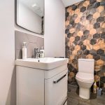 Modern bathroom with hexagonal tile wall.