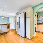 Modern kitchen with fridge and blue walls.