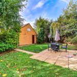 Sunny garden with patio and outdoor seating area.