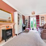 Cosy living room with fireplace and large window.