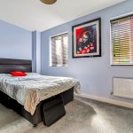 Modern bedroom with artwork and black furniture.