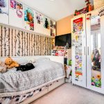 Cosy bedroom with cat, teddy, and decorated closets.