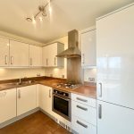 Modern kitchen with white cabinets and appliances.