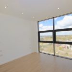 Bright empty room with large window view.