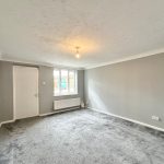Empty grey living room with carpet flooring.