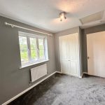 Empty room with grey walls and carpet.