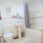 Modern white bathroom with bathtub and sink.
