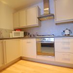 Modern kitchen with white cabinets and appliances.