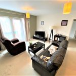 Modern living room with leather sofas and TV.